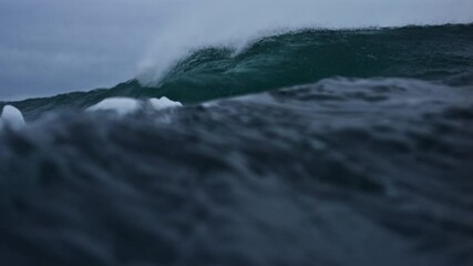 Slow motion detail of dark, rough Atlantic waves with mist and ocean spray on stormy day
