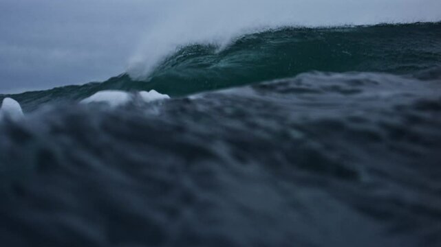 Slow motion detail of dark, rough Atlantic waves with mist and ocean spray on stormy day