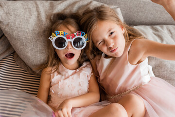 Two little girls in fancy dresses celebrate their birthday