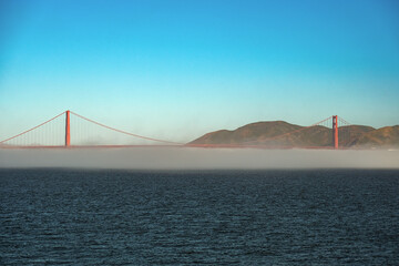 World famous red steel suspension bridge in San Francisco port entrance with Golden Gate State park...