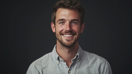 Obraz premium A happy male studio portrait with a bright smile, showcasing warmth and approachability