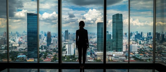 Fototapeta premium Silhouette of a woman looking at cityscape