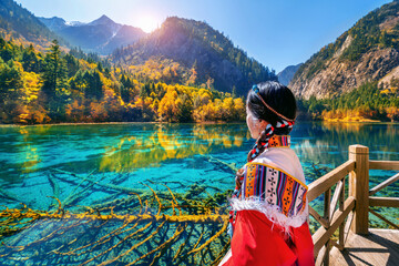 Tourist wearing traditional clothes at jiuzhaigou national park in autumn, Sichuan, China.