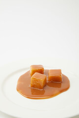 caramel candies and caramel sauce isolated on a white background