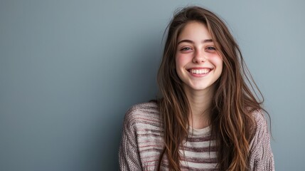 Fototapeta premium A playful female studio portrait of a young woman with a bright smile and casual attire