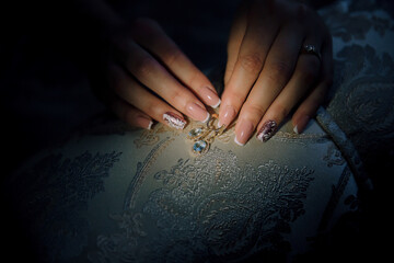 Obraz premium A woman is holding a piece of jewelry with her hand. The jewelry is a diamond pendant