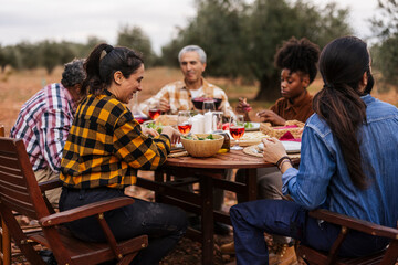 Farmers enjoying lunch together in olive grove after harvesting olives