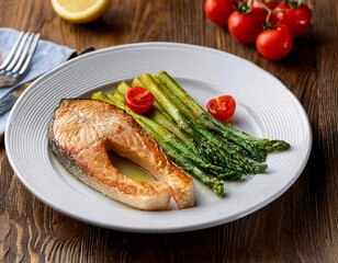 Fried salmon steak with cooked green asparagus, cherry tomatoes and lemon slices served on white plate on wooden table