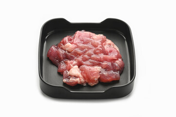 Marinated tender pork in black tray on white background.
