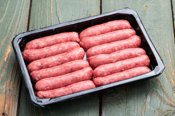 Raw beef sausages with rosemary and tomatoes photography . Top view