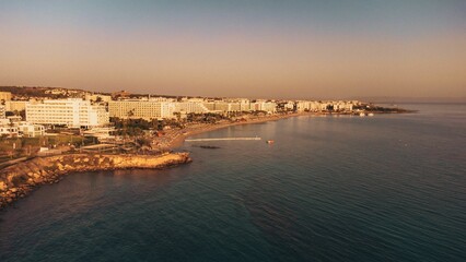 Coastal cityscape with hotels at sunset.