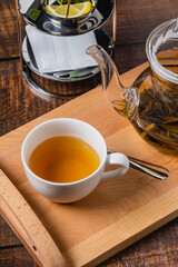 Herbal tea or linden tea in white porcelain cup on wooden table