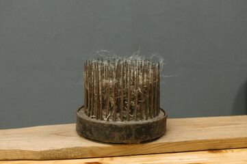 Traditional wool carding comb on wooden surface for textile crafting