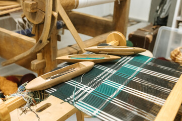 Traditional loom weaving with wooden shuttles and colorful textile patterns