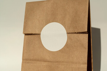 Brown paper bag with white round sticker on fold