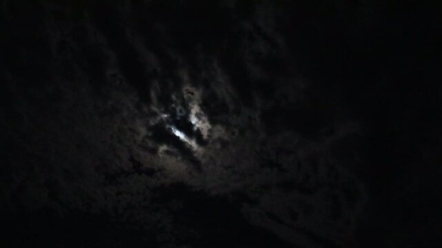 Night Sky with Moon and Moving Clouds. Full Moon Behind Cloudy Night Sky. Mystical Full Moon in Cloudy Darkness. Nighttime Sky with Full Moon and Clouds