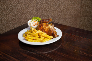 Pollo a la brasa con papas fritas y ensalada