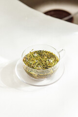 Process brewing tea, tea ceremony. Cup of freshly brewed black tea,warm soft light and fresh leaves