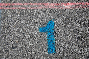 Grey street with blue painted number 1 and red stripe