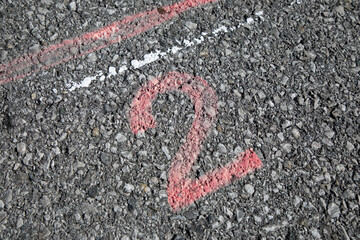 Grey street with blue painted number two 2 and red stripe