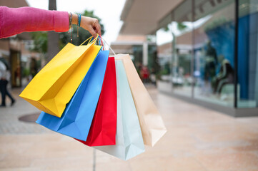 Woman holding colorful shopping bags at the mall