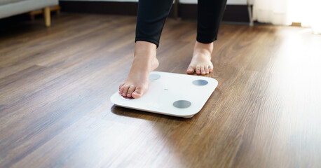 Lose weight. Fat diet and scale feet standing on electronic scales for weight control. Measurement instrument in kilogram for diet.