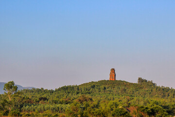 Phu Loc Tower - an ancient Champa tower - glowing red in the sunset, built on top of a low hill in...