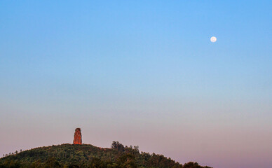 Phu Loc Tower - an ancient Champa tower - glowing red in the sunset, built on top of a low hill in...