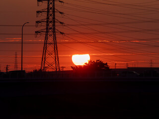 真っ赤な夕日と送電鉄塔