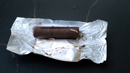 Worms crawls on chocolate candy. Crawling larvae and eggs laid on food. Not fresh spoiled product....