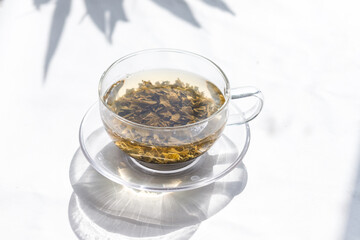 Process brewing tea, tea ceremony. Cup of freshly brewed black tea,warm soft light and fresh leaves