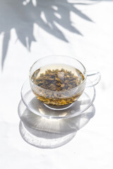 Process brewing tea, tea ceremony. Cup of freshly brewed black tea,warm soft light and fresh leaves