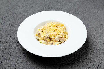 Italian pasta with mushrooms and parmesan cheese. On a gray background.