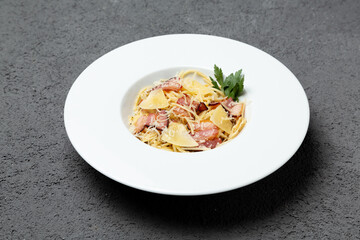 Italian pasta with bacon and parmesan cheese. On a gray background. Photo for the menu.