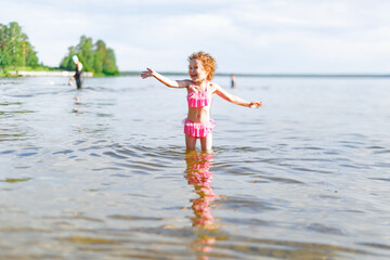 Cute girl playing on the beach with a sand and water on beach