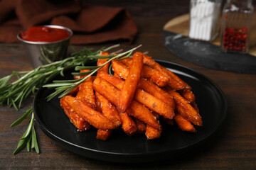 Sweet potato fries and rosemary on wooden table, closeup