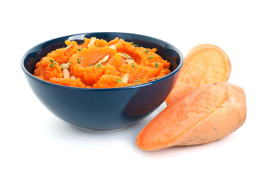 Tasty mashed sweet potato with pumpkin seeds in bowl and cut vegetables isolated on white