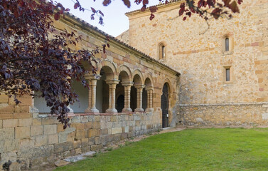 Obraz premium A medieval stone building with a courtyard in front of it. The courtyard is surrounded by arches
