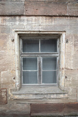 old glass window in old house with sand stone bricks, vertical format