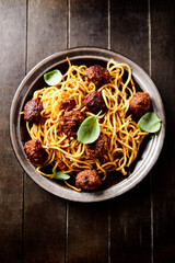 Spaghetti Pasta with Meatballs and fresh Basil on dark background. Top view. 