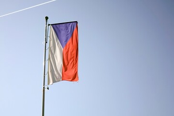 Czech national flag with blue sky and backlight, copy space