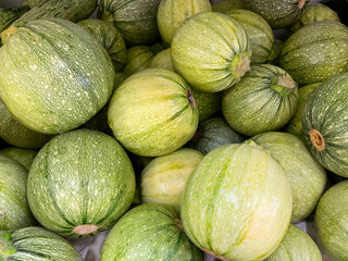 Close up of fresh round zucchini for sale at city market. Top view. Fresh organic green zucchini. Local harvest, organic produce at Laiki Agora on the streets of Greece. Vegetable images
