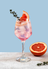 Refreshing grapefruit cocktail with ice and thyme. Cocktail of fresh pink Paloma
