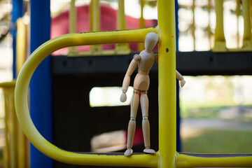 秋の公園の遊具施設に座る可愛いマネキン人形の様子