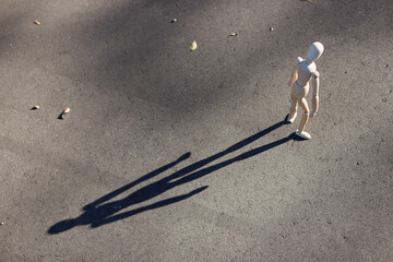 夕方の公園の道路に立っている可愛いマネキン人形の様子