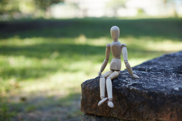 秋の公園のベンチに座る可愛いマネキン人形の様子