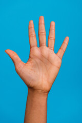 Vertical cropped view of attractive girl hand showing five perfect sign isolated over bright blue...