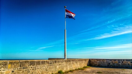 A solitary flagpole pierces the azure sky, its base anchored on weathered stone.