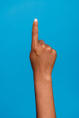 Cropped closed up vertical photo of girl hand finger direct up empty space one isolated on blue...