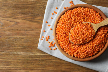 Red lentils in a bowl on wooden background 
